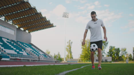 Professional-Male-soccer-player-athlete-on-the-football-field-in-slow-motion-in-sports-gear-juggling-a-soccer-ball